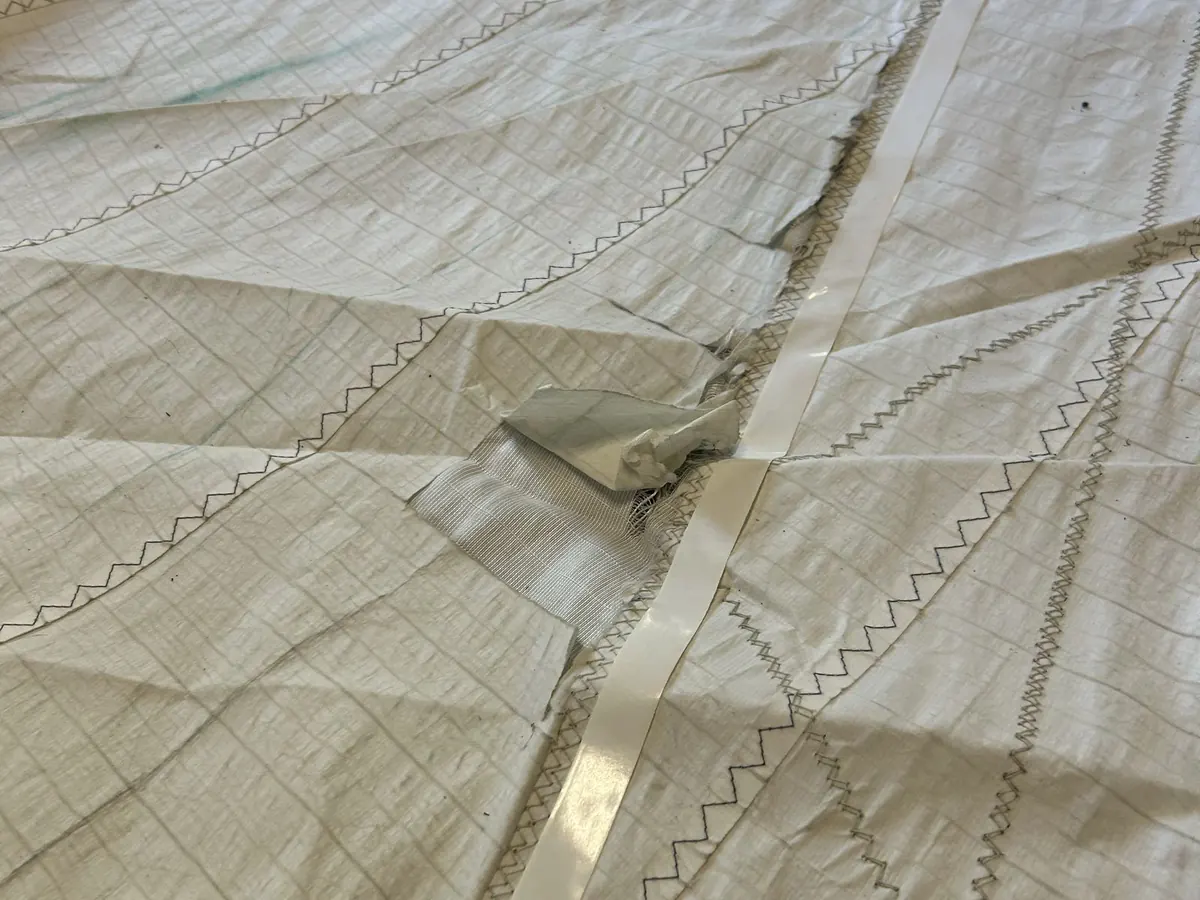 Déchirure sur une voile laminée, avant réparation en voilerie