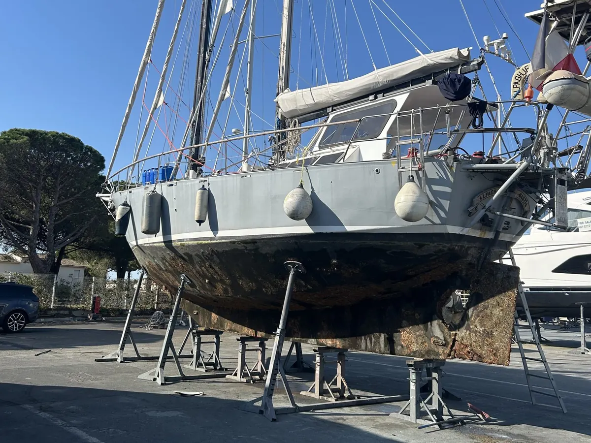 Voilier de grand voyage à terre, avec portique, éolienne et équipements d’autonomie